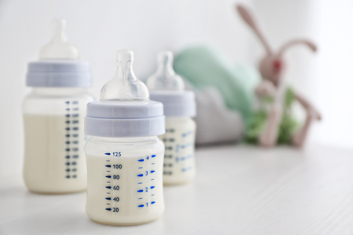 Baby Milk Bottles and Toys on White Background